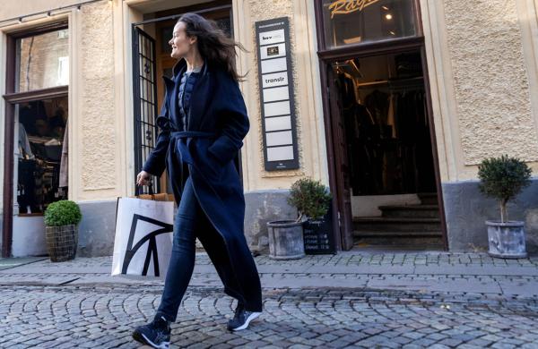 Kvinna som går med shoppingkasse i stadsmiljö